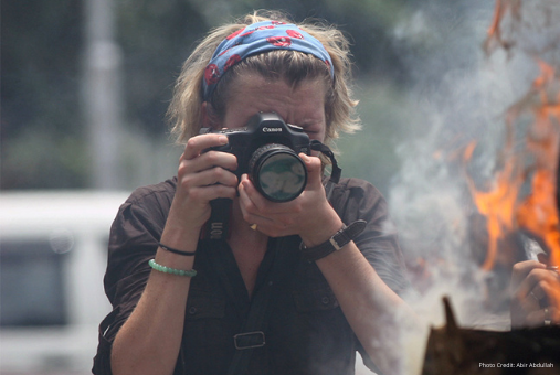 women journalist photographing in risky situation
